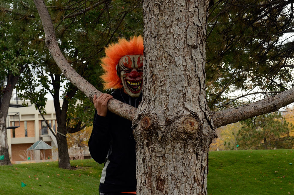 Clowns pose problems for local law enforcement Creepy clown behind a tree