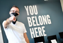 Gender and Sexuality Student Resource Center strives to cultivate community Peter pointing at camera next to "You Belong Here" on back wall