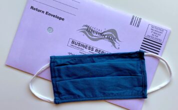Voting in light of COVID-19 American election mail envelope with face mask