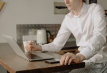 Online classes become new normal; pants optional Man in white dress shirt using Macbook Pro