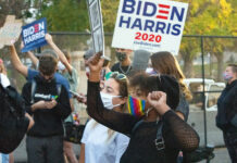 Protesters eye bigger issues than Pence and Harris Black protester wears rainbow-colored mask