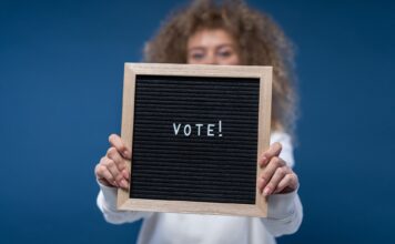 Voter education: Getting young voters to the polls Person holding a "Vote!" sign