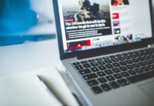 Panel discussion on media literacy to include SLCC faculty, former student News website on gray laptop next to journal
