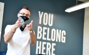 Gender and Sexuality Student Resource Center extends virtual help to lonely students Peter Moosman stands in front of wall that reads "You belong here"