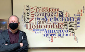 How SLCC serves its military community Steve Hill stands next to military word cloud shaped like United States