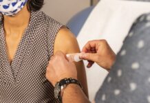 Latin community hit hard by pandemic Bandage applied to vaccine injection site