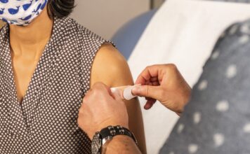 Latin community hit hard by pandemic Bandage applied to vaccine injection site