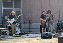 Thunderstorm forces lively Bearfoot Music Festival indoors Three people playing guitar at outdoor concert