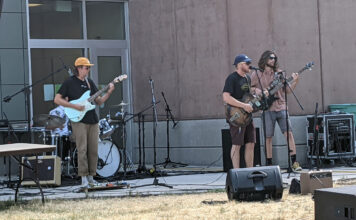 Thunderstorm forces lively Bearfoot Music Festival indoors Three people playing guitar at outdoor concert