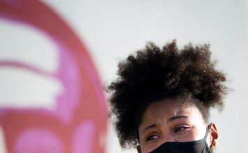 Higher education reacts to CRT debate Rae Duckworth holds a megaphone