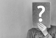 Relating to imposter syndrome Person holding up a question mark over their face