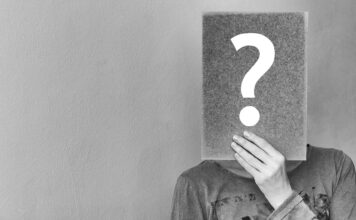 Relating to imposter syndrome Person holding up a question mark over their face