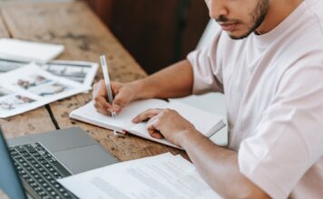 Finishing the semester strong: Professors share productivity tips Crop student writing in agenda at desk with laptop