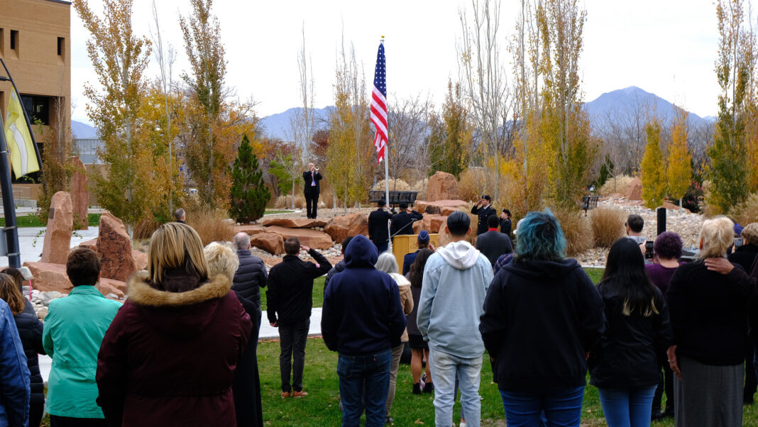 Dozens of people salute the American Flag