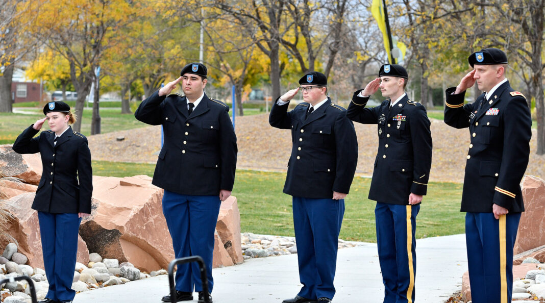 Five ROTC cadets saluting