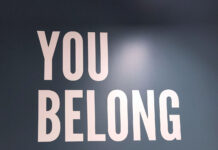 ‘You are not alone’: Queer Student Association supports LGBTQ students Lauren Hamilton-Soule stands in front of "You Belong Here" wall