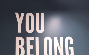 ‘You are not alone’: Queer Student Association supports LGBTQ students Lauren Hamilton-Soule stands in front of "You Belong Here" wall