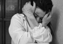 Dirty words: Domestic violence; lifting the stigma Stop written on battered woman's hand as she holds bruised arms over her face