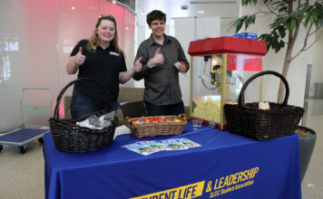 Back to school: SLCC Student Association Two people give thumbs up at the Student Life & Leadership table