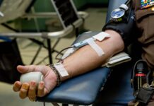 LGBTQ community questions blood, plasma donor qualifications Person on chair donating blood