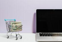 Student Beans offers deep student discounts Shopping cart with money next to a laptop
