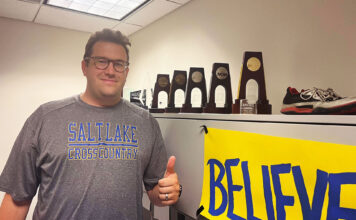 Ready to run: New SLCC cross country team finds its coach Isaac Wood gives a thumbs-up while standing next to a shelf of NCAA trophies