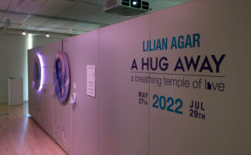Art exhibit that opened at SLCC embraces Utah’s LGBTQ youth Display wall reads "Lilian Agar: A Hug Away - a breathing temple of love"