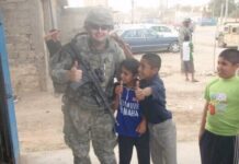 Longtime listener, first-time voter Sean Stetson poses for a picture with Iraqi children