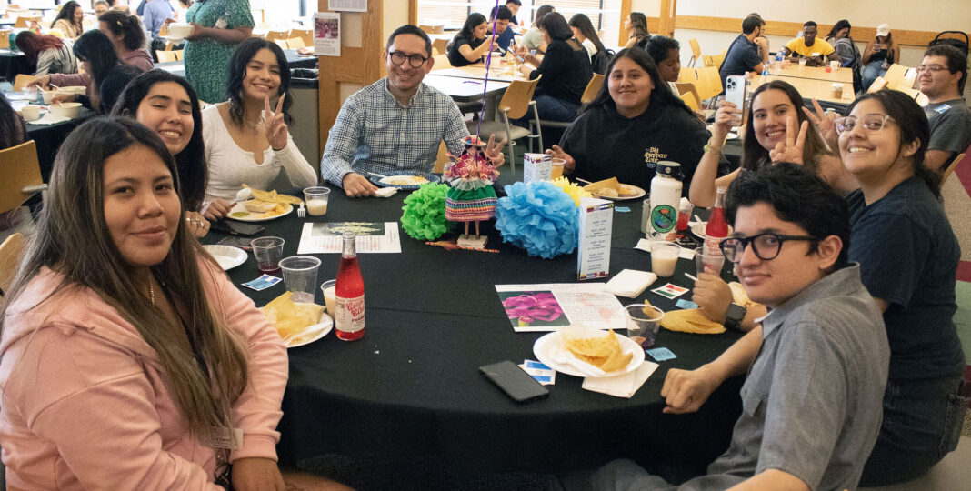 Eight students eat lunch at a round table