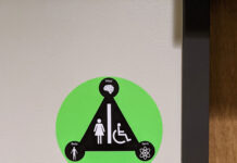 Letter to the editor: Inclusive bathroom signage pilot program Green dot indicating inclusive restroom above conventional women's restroom sign