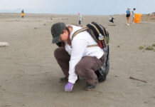 SLCC students show up for the Salt Lake during this year’s coastal cleanup Person crouches down to pick up garbage