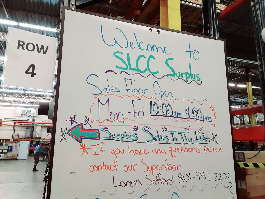 SLCC surplus information on a whiteboard next to row 4 in a warehouse