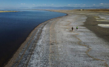 Utah legislature eyes changing approach to saving Great Salt Lake Two people walk along receded Great Salt Lake shoreline
