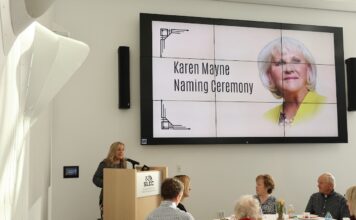 Section of Westpointe Center named after retired Sen. Karen Mayne Deneece Huftalin at podium during Karen Mayne naming ceremony