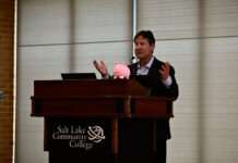 SLCC won’t increase its tuition this upcoming year, college announces Brent Perozzi speaking at podium with a piggy bank on the podium