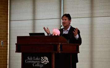 SLCC won’t increase its tuition this upcoming year, college announces Brent Perozzi speaking at podium with a piggy bank on the podium