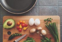 How SLCC students can boost their nutrition on a budget Knife resting on a kitchen cutting board with avocado, tomatoes, eggs, mushrooms, spring onions, and leaves