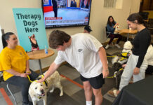 3-day event helps students relax during finals, reminds them of available help Student in white t-shirt pets a golden retriever