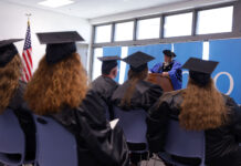 23 students graduate from SLCC’s Prison Education Program Two rows of graduates sitting and listening to David Bokovoy speak at podium