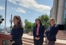 Opposing parties present their cases regarding Utah’s abortion law injunction Julie Murray and Lisa Petersen watching Camila Vega speak at a podium outside the Matheson Courthouse