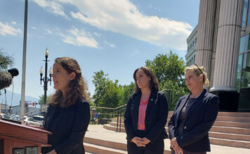 Opposing parties present their cases regarding Utah’s abortion law injunction Julie Murray and Lisa Petersen watching Camila Vega speak at a podium outside the Matheson Courthouse