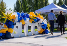 Photos: SLCC marks 75th anniversary with tribute and capsule event Two people walking past SLCC block letters decorated in school colors
