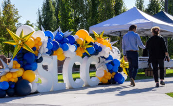 Photos: SLCC marks 75th anniversary with tribute and capsule event Two people walking past SLCC block letters decorated in school colors