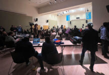 Student bands dial it to 11 with song covers for on-campus concert Sound technicians in foreground, audience and bands near stage in background
