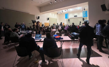 Student bands dial it to 11 with song covers for on-campus concert Sound technicians in foreground, audience and bands near stage in background