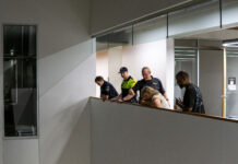 Recent campus walkabouts seek to rectify safety and accessibility issues Security officials looking down while explaining possible security improvements at Herriman Campus