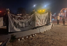 Salt Lake residents gather for 5th annual Harvey Milk vigil People holding cloth banners with handwritten messages and lit candles on a sidewalk