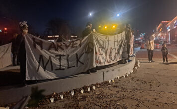 Salt Lake residents gather for 5th annual Harvey Milk vigil People holding cloth banners with handwritten messages and lit candles on a sidewalk