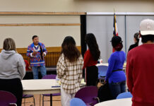 Indigenous storyteller, filmmaker tells Ute tales for SLCC event Larry Cesspooch, facing audience, leads a prayer on stage