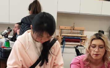 Fashion club hosts crafting event to celebrate Valentine’s Two students working with pink paper to make Valentine's crafts